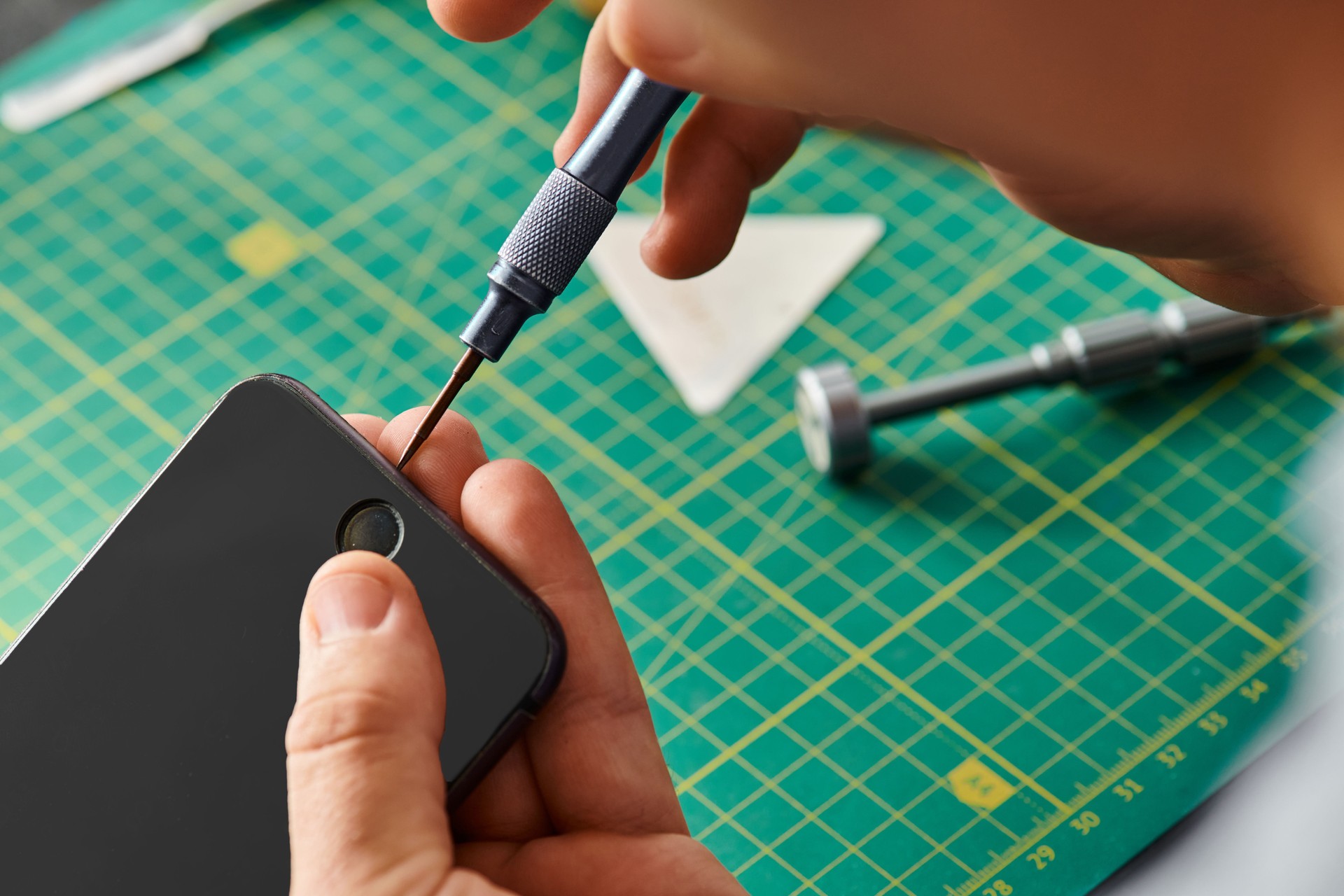 Hands of a skilled technician repairing a smartphone at a service center